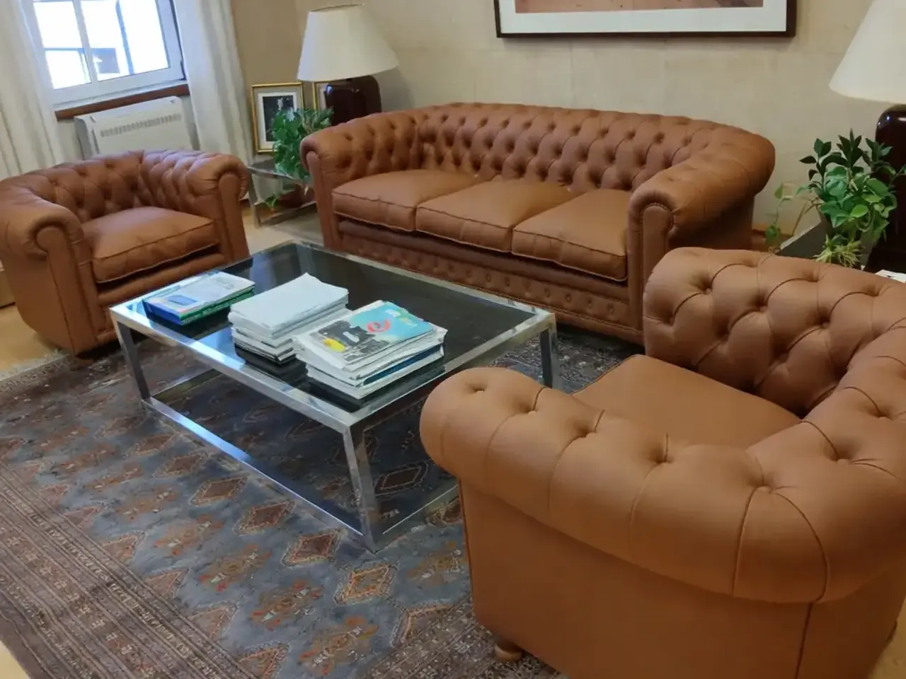 Juego de sillones Chesterfield de cuero marrón con capitoné profundo en un living