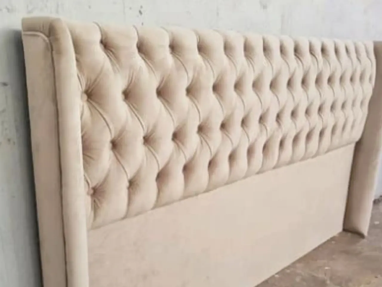 Respaldo de cama tapizado en capitoné beige con botones forrados