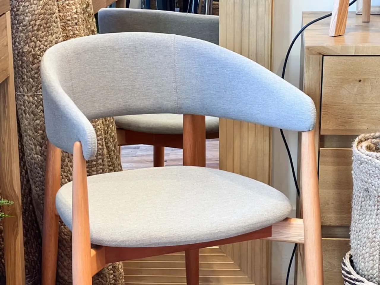 Silla de respaldo curvo con el asiento en tela crema y el respaldo en tela celeste